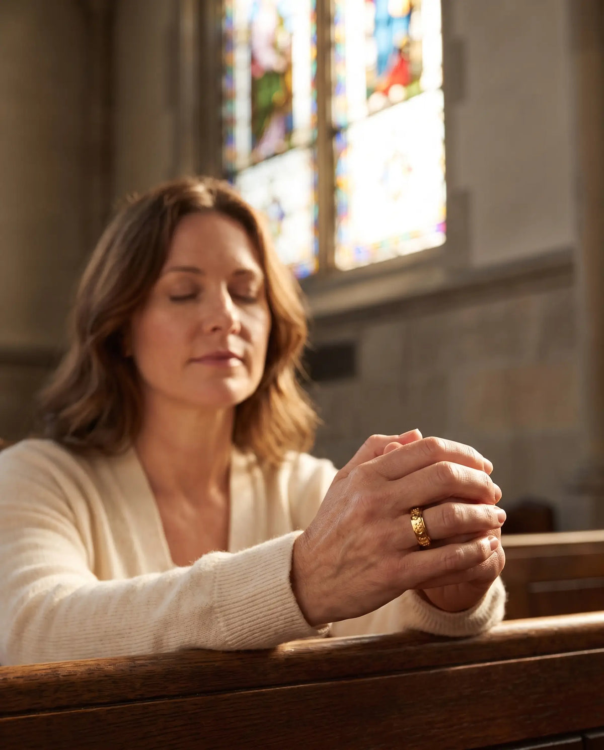 Woman praying in church wearing the Day & Night Prayer Spinner Ring